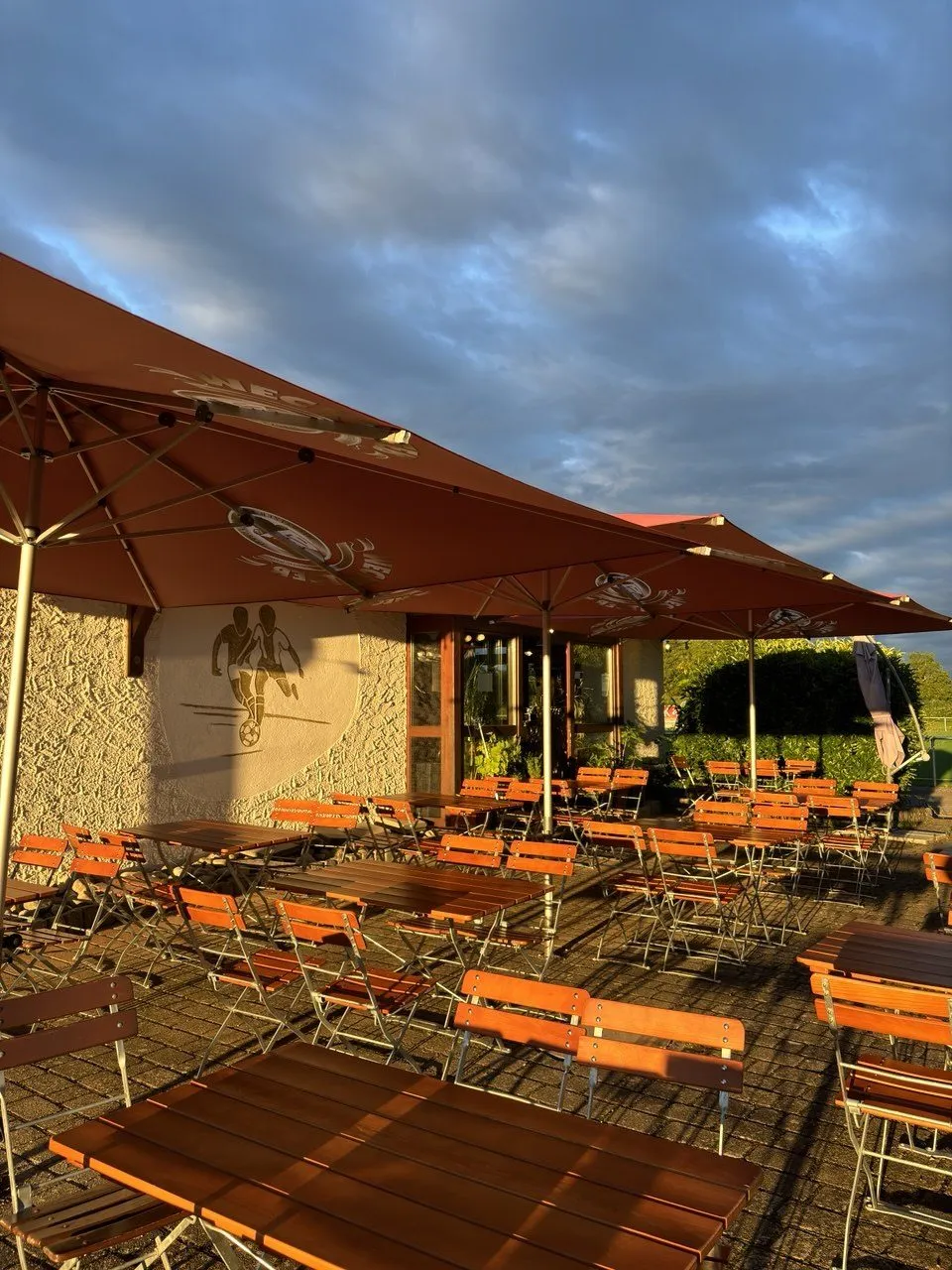 Leere Stühle im Biergarten bei Sonnenuntergang